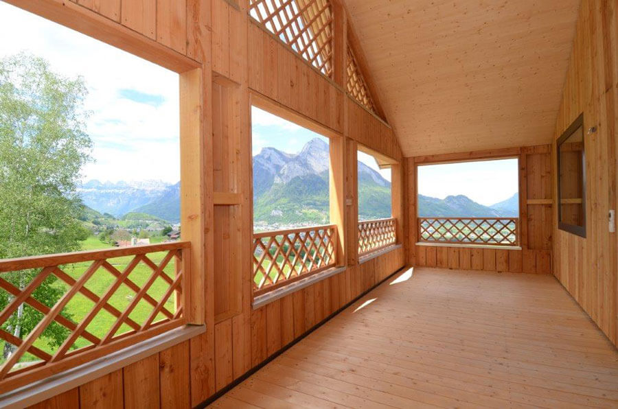 Gehaltene Loggia mit Aussichtsfenstern. Boden, Geländer und Dach in Holz.