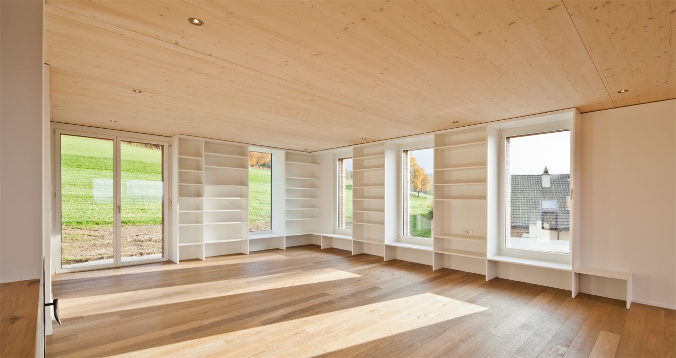Viele Abstellmöglichkeiten sind harmonisch unter die Fenster gemischt, die natürliches Licht in den Raum bringen.