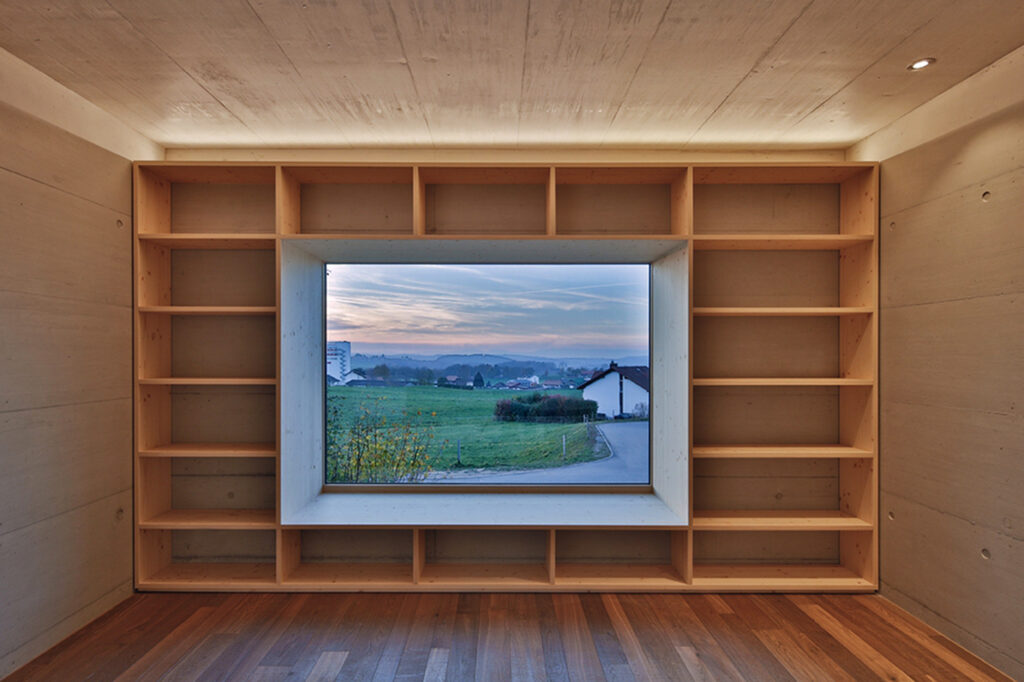 Ein von Ablagefläche umgebenes Sitzfenster mit Blick auf die Freiburger Umgebung.